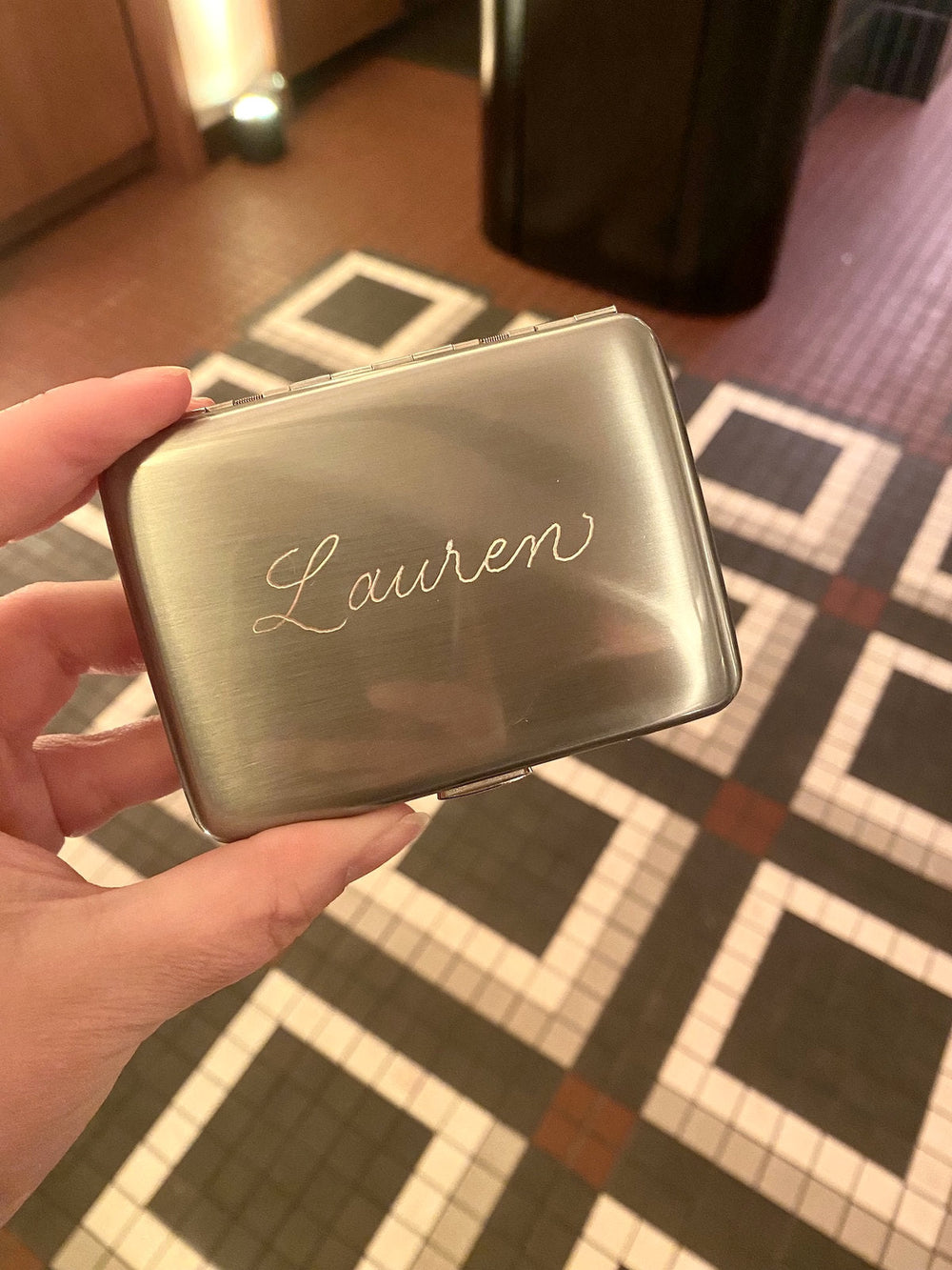 Personalized silver cigarette case hand engraved with the name Lauren for So & So's Piano Bar opening in New York City.
