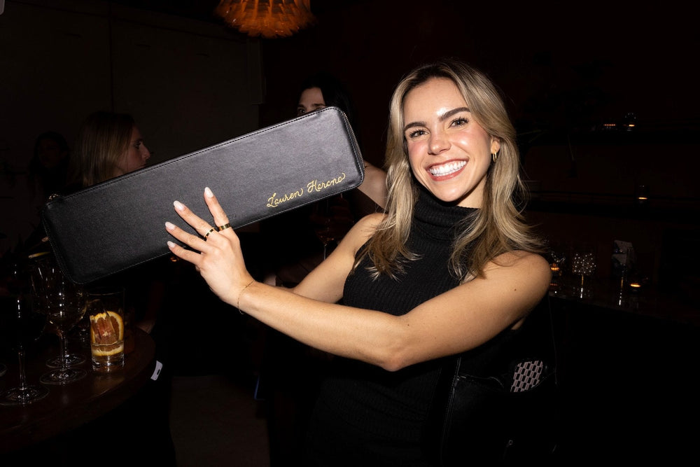 Personalized Kristin Ess leather cases featuring custom gold foil lettering for a New York City beauty brand launch.
