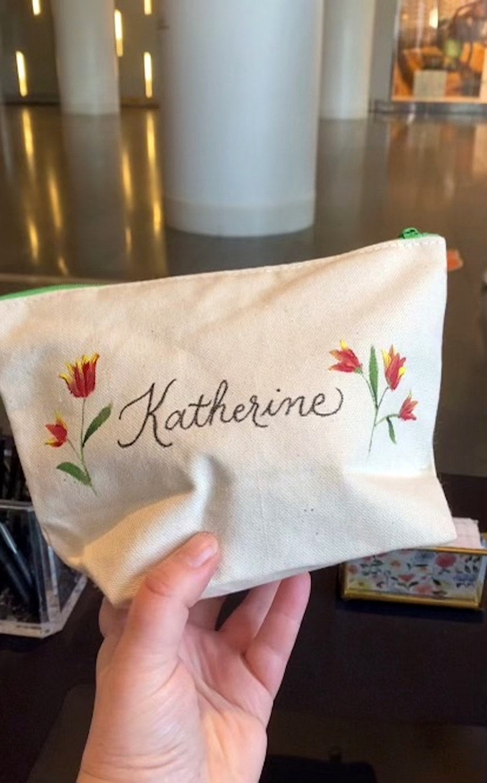 Custom calligraphy on a canvas pouch decorated with hand-painted red tulips for a Brookfield Place event in New York City.