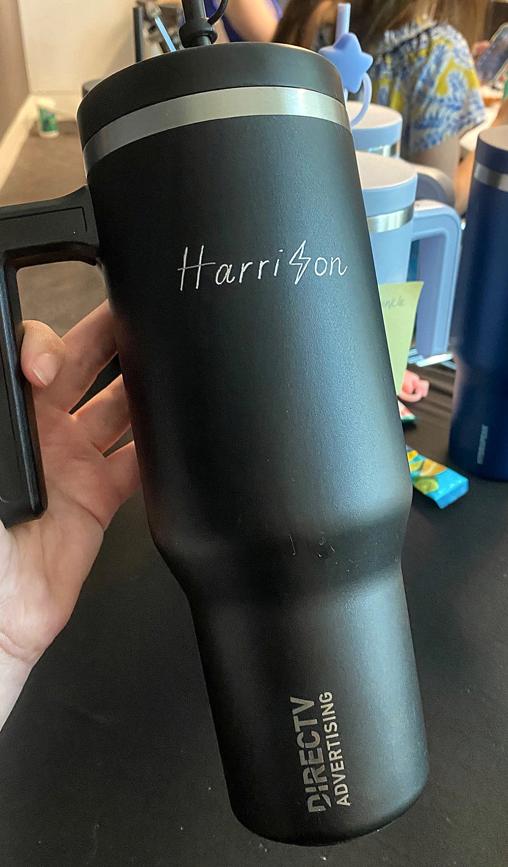 Black tumbler personalized with hand-engraved lettering and a lightning bolt for a DIRECTV Advertising corporate event in NYC.