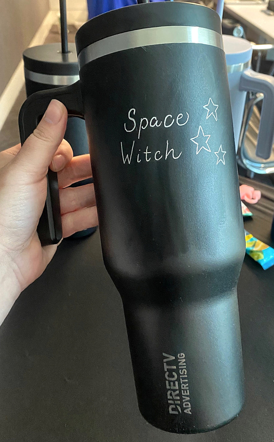 Custom hand engraving on a black tumbler featuring playful lettering and stars for a DIRECTV Advertising corporate event in NYC.