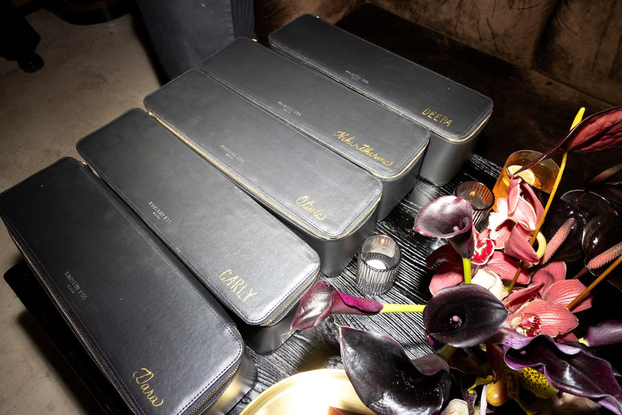 Black Kristin Ess leather styling cases personalized with gold foil names at a NYC product launch event by The Poppy Pen.