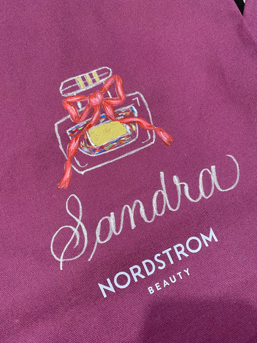 Personalized Nordstrom Beauty tote bag featuring a hand-painted perfume bottle with a red bow and the name Sandra in white calligraphy.