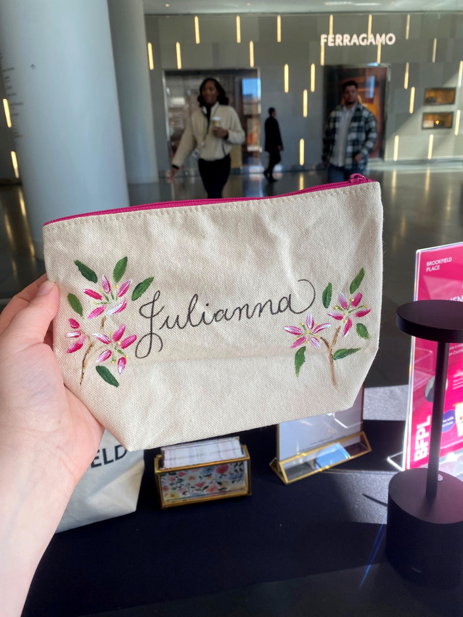 Hand-painted canvas pouch with pink flowers and custom calligraphy created for a Brookfield Place brand activation in NYC.