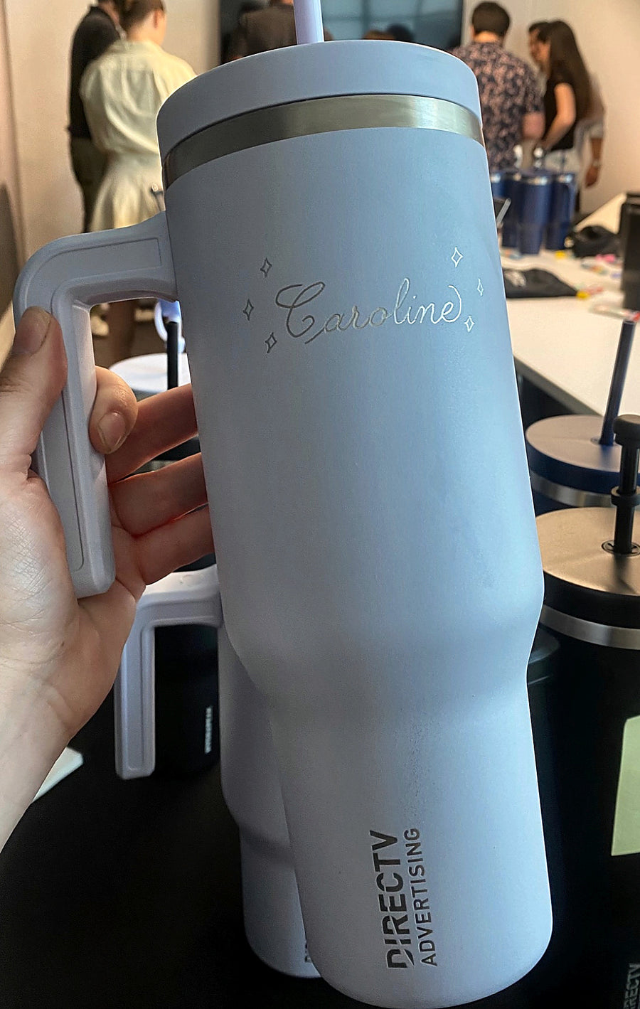 Personalized blue tumbler with elegant script calligraphy and decorative details, hand engraved for a DIRECTV Advertising event in New York City.