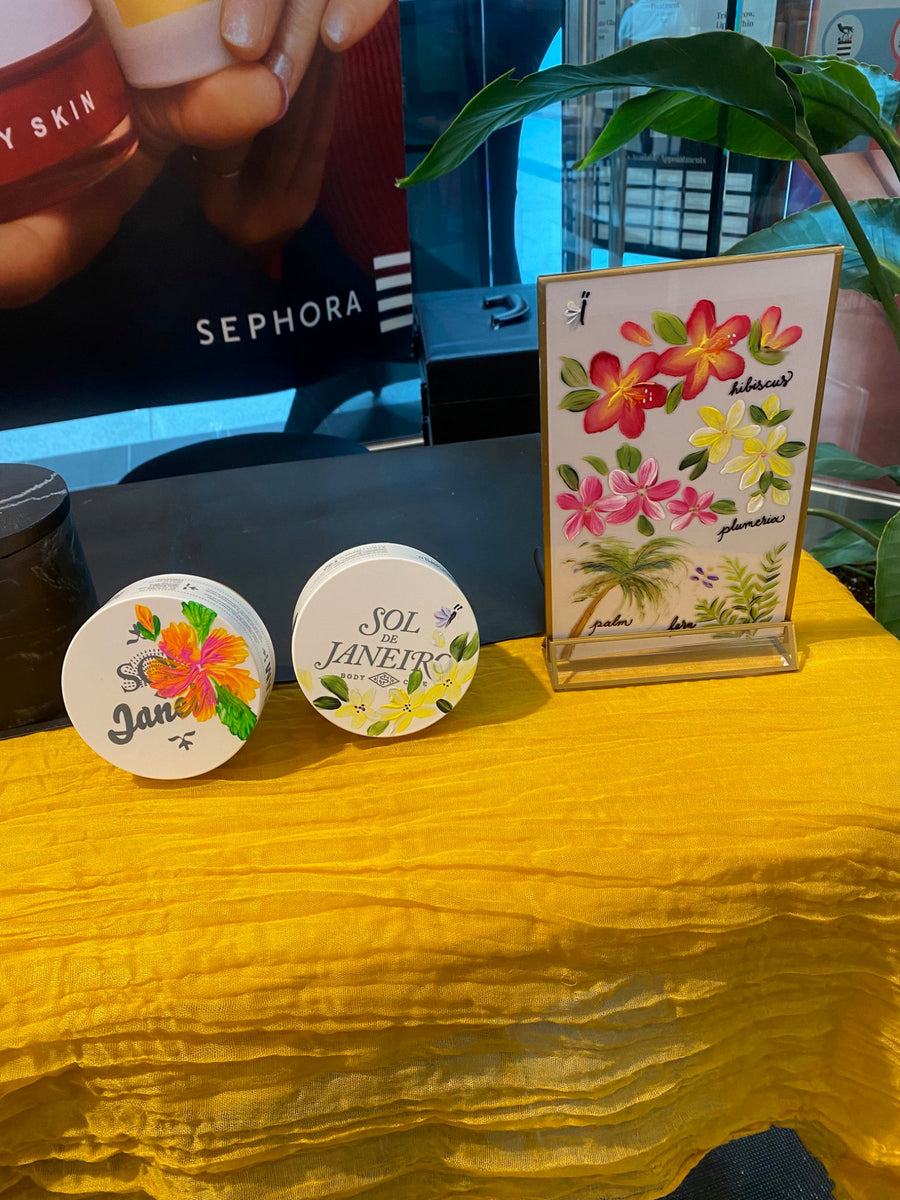 Live Sol de Janeiro product painting display at Sephora featuring floral-painted beauty products and a hand-painted tropical design menu.