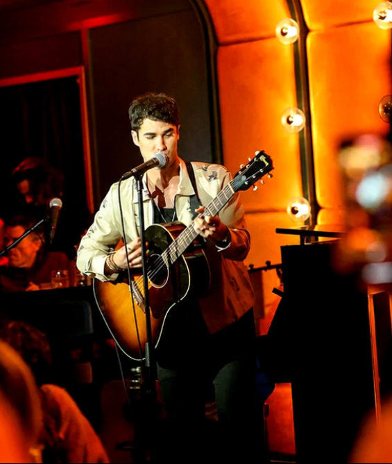 Darren Criss performing live with his guitar at the grand opening of So & So's Piano Bar in Hell's Kitchen, NYC.