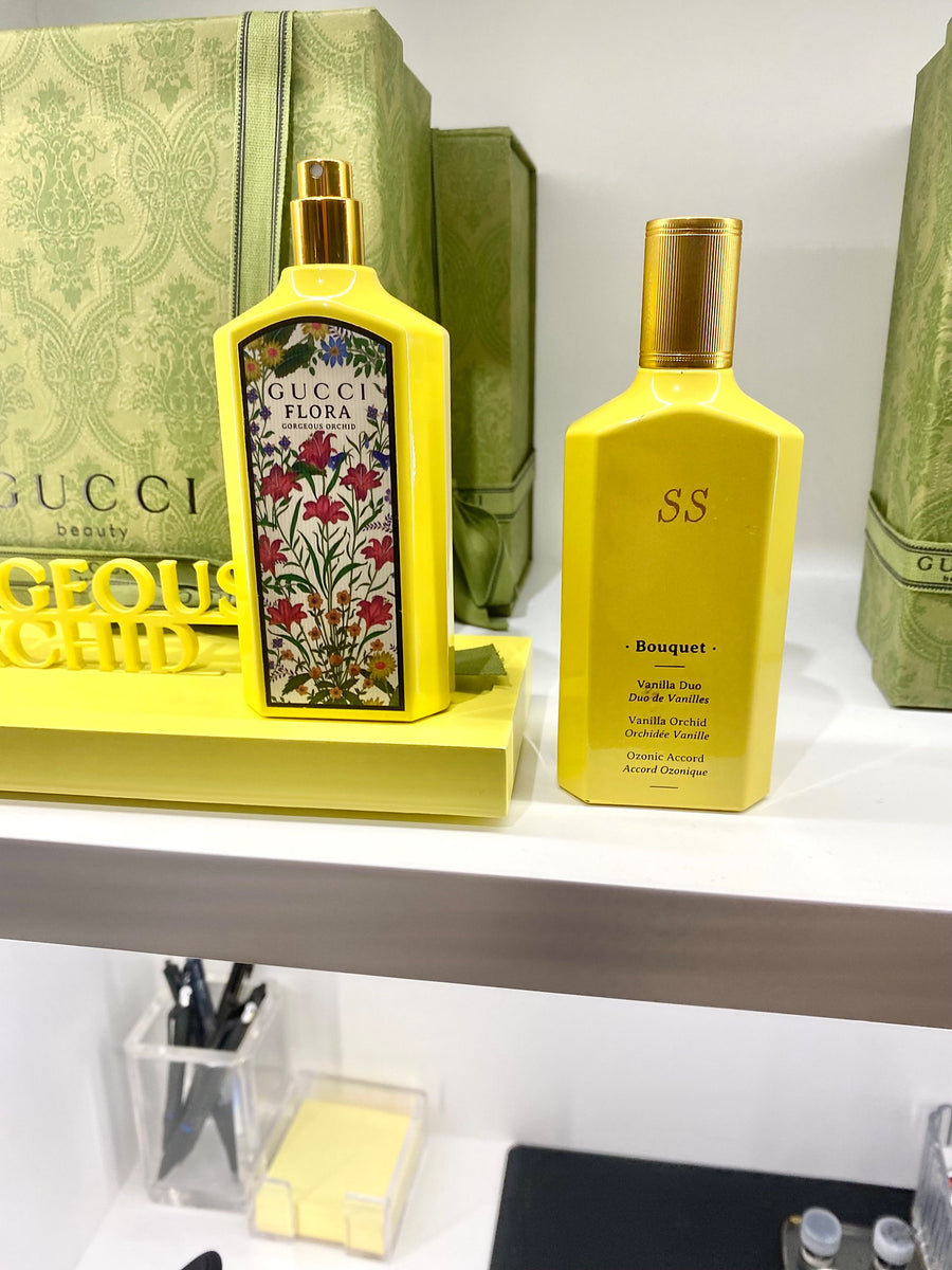 Yellow Gucci Flora Gorgeous Orchid perfume bottles and branded packaging at a New York City fragrance event.