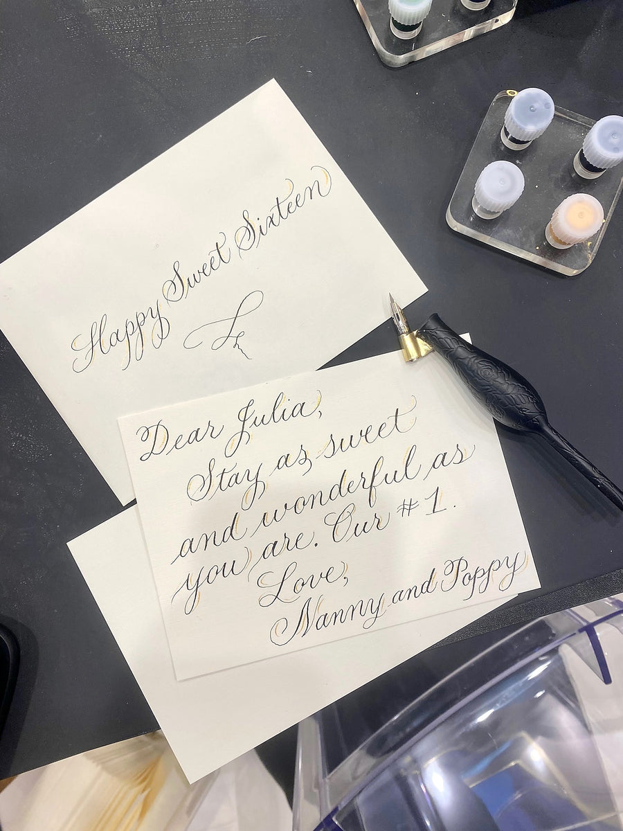 Custom handwritten birthday cards featuring elegant script calligraphy and delicate gold accents at a LAGOS Jewelry live calligraphy event in New York City.