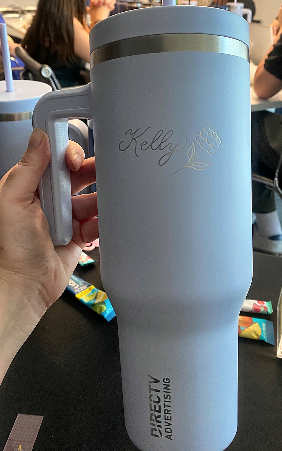 Live event engraving on a blue tumbler featuring a custom calligraphy name and delicate floral illustration in NYC.