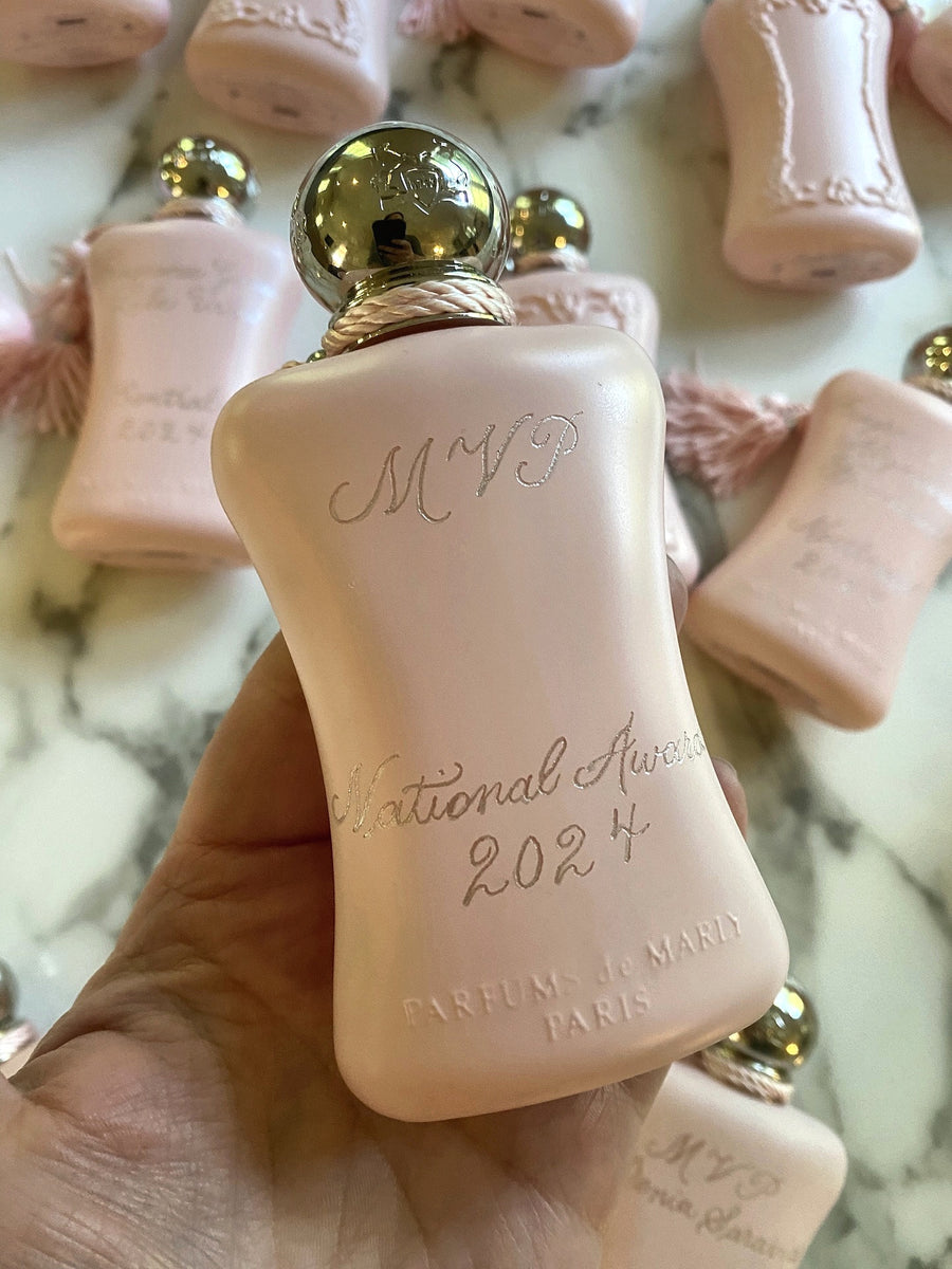 Personalized pink Delina perfume bottle with hand engraved MVP and National Awards lettering for Parfums de Marly corporate gifting.