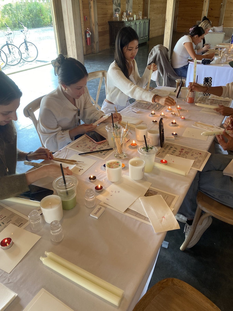 Hand-painted taper candle with decorative ribbon designs created during the Being Frenshe candle painting workshop.
