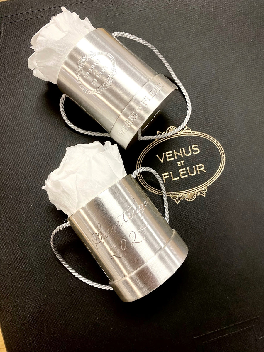 Hand-engraved Venus et Fleur silver rose holders displayed beside the luxury brand's gold logo