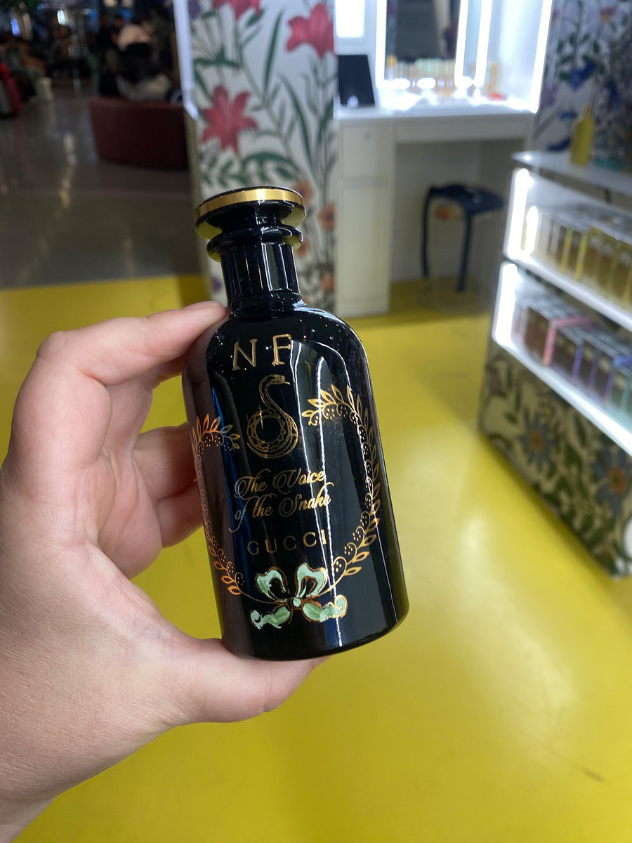 Black Gucci The Voice of the Snake fragrance bottle with personalized initials and ornate gold detailing.