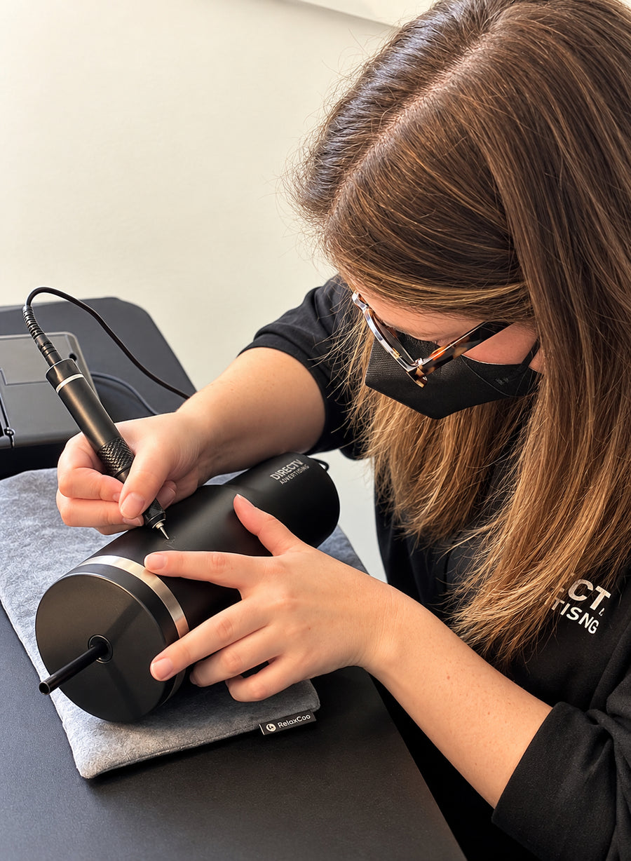 The Poppy Pen artist hand engraving personalized tumblers during a live corporate event for DIRECTV Advertising in New York City.